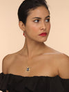 Model wearing gold earth necklace with blue enamel, diamonds and ruby detailing.