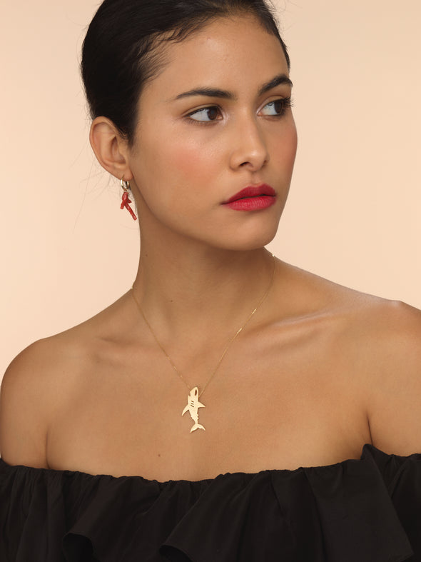 Model wearing gold shark necklace