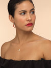 Model wearing small gold moon necklace.