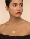 Model wearing gold necklace with diamond recycle symbol.