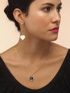 Model wearing gold heart earring with diamond stud detailing. 